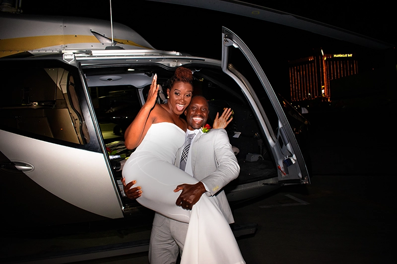 Groom holds the bride by a helicopter